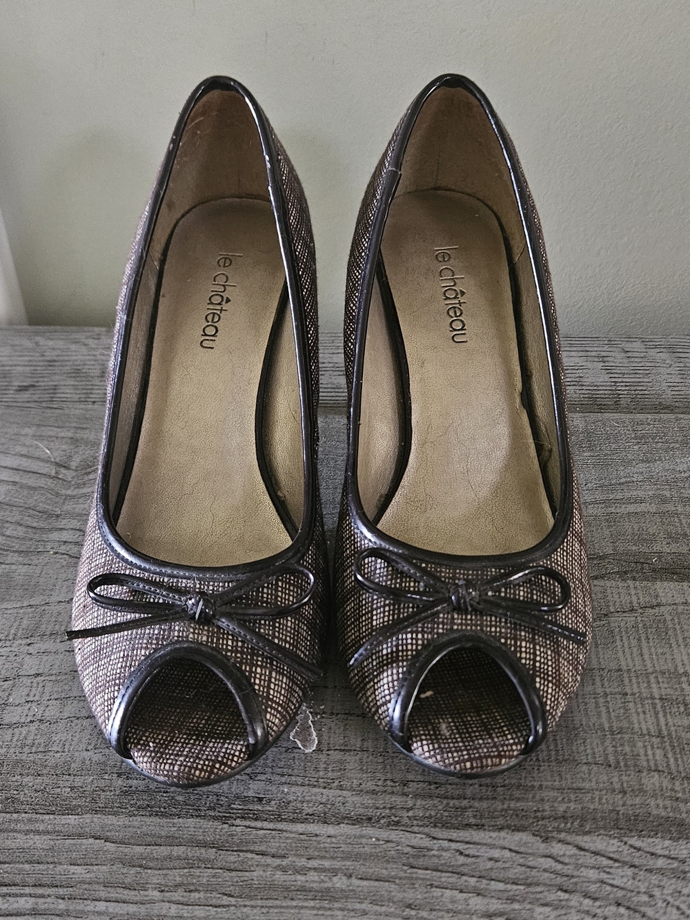 Le Chateau peep-toe pumps feature a metallic bronze fabric upper with Bow